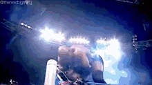 a wrestling match is taking place in a dark room with a lot of lights on .