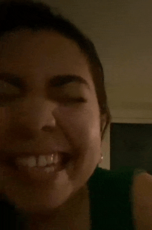 a close up of a woman making a funny face with her eyes closed .