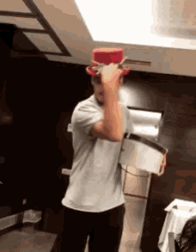 a man wearing a white shirt and a red top hat is holding a bucket