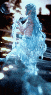 a woman in a blue dress is holding a bubble in her hand