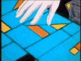 a close up of a person 's hand on a blue and yellow tile floor