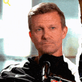 a man wearing a nike jacket looks at the camera