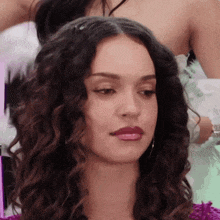 a woman with curly hair is getting her hair styled
