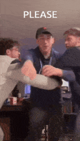 a group of men are standing next to each other in a room with a sign that says please