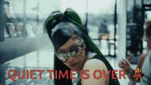 a woman wearing sunglasses and a ponytail is standing in front of a sign that says quiet time is over