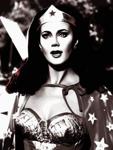 a black and white photo of wonder woman with a red cape