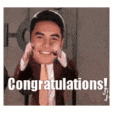 a man in a suit and tie is smiling and saying congratulations
