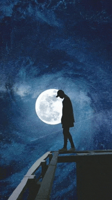 a silhouette of a man standing on top of a bridge in front of a full moon .