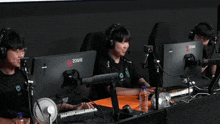 a group of people are sitting in front of monitors that say zowie