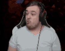 a man wearing headphones and a white shirt is making a funny face