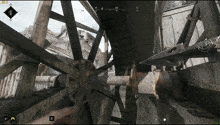 a screenshot of a video game shows a person holding a sword in front of a large wheel