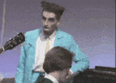 a man in a blue jacket is standing next to another man in a white shirt and tie