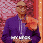 a man in a purple suit is holding a flower and says my neck
