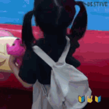 a girl with pigtails is holding a stuffed animal and a white backpack