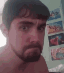a man with a beard is making a funny face while taking a selfie .