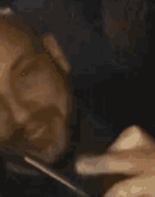 a close up of a person 's face with a cell phone in their mouth .