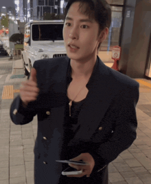 a man in a suit holds a cell phone in his hand