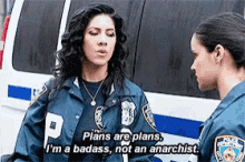 two police officers are talking in front of a van and one of them says plans are plans .