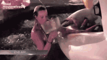 a woman is drinking from a bottle in a hot tub that says real housewives