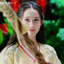 a girl in a yellow dress with chinese writing on the bottom right corner