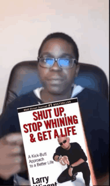 a man is holding a book titled shut up stop whining & get a life