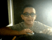 a young boy wearing glasses is using a mouse