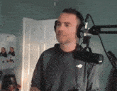 a man wearing headphones is standing in front of a microphone with a bird on his shirt