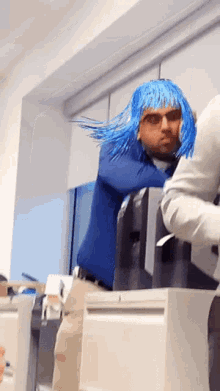 a man wearing a blue wig and sunglasses is standing in front of a printer