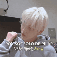 a man with white hair is wearing a grey hoodie with the words pov sos solo de pilar on the bottom