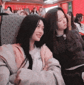 two girls are sitting on a bus with one wearing a shirt that says ' i love you ' on it