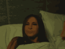 a woman is hiding her face under a blanket