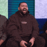 a man with a beard is laughing while playing a video game
