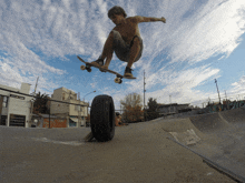 a skateboarder is doing a trick with a tire in the foreground