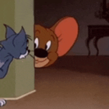 tom and jerry are peeking out from behind a wall .