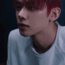 a close up of a man with red hair wearing a white shirt .