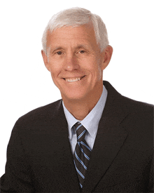 a man in a suit and tie smiles at the camera