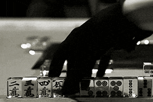 a person is playing a game of mahjong with chinese characters