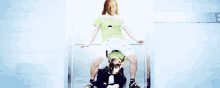 a man in a green shirt sits on a chair next to another man