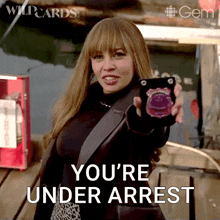 a woman holding a cell phone with the words you 're under arrest