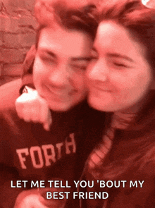 a man wearing a forth sweatshirt hugs a woman