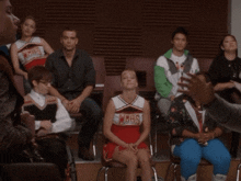 a woman in a wmhs cheerleading uniform sits in a classroom