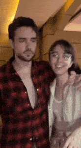 a man and a woman are posing for a picture together .