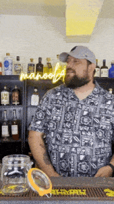 a man in a hawaiian shirt is standing in front of a neon sign that says manoof