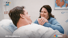 a poster for st denis medical shows a woman holding a man 's hand and smiling