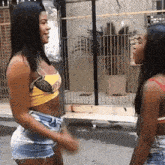 two women are standing next to each other on the street