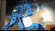 a blue robot is standing in a room with a blurred background