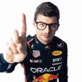a man wearing glasses and a red bull jacket is giving the peace sign .