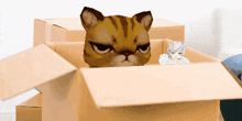 a cat is peeking out of a cardboard box next to another cat