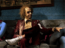a man in a costume sits on a couch