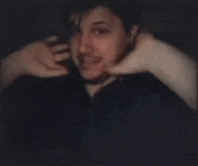 a man with a beard is making a funny face with his hands on his face .